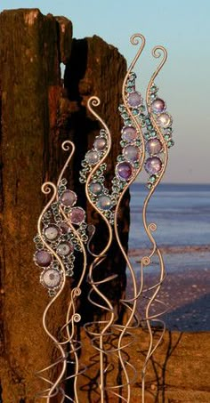 a metal sculpture sitting on top of a beach next to the ocean