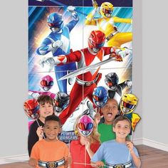 children posing in front of the power rangers wallpaper mural, which is part of an indoor play area