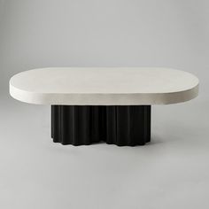 an oval table with three black columns on the top and one white column at the base