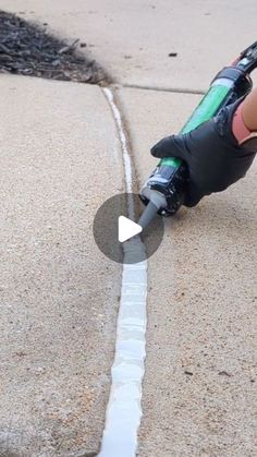 a person is using a tool to fix a street drain