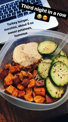 there is a bowl with some food in it on the table next to a laptop