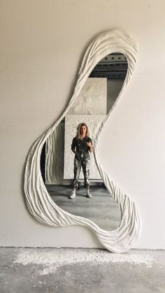 a woman is taking a selfie in a mirror with her reflection on the wall