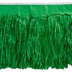 a green table cloth with fringes on it