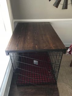 a dog crate sitting on the floor next to a wall with a clock above it