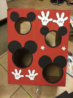 a cardboard box with mickey mouse cutouts on it's sides and holes in the middle