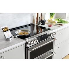 a stove top oven sitting inside of a kitchen next to a counter with food on it