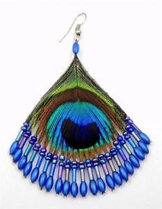 peacock feather earrings with blue beads hanging from the earwires on a white background