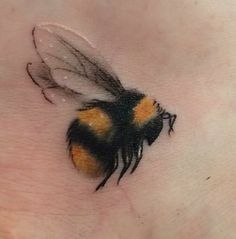 a small tattoo of a bee on the stomach