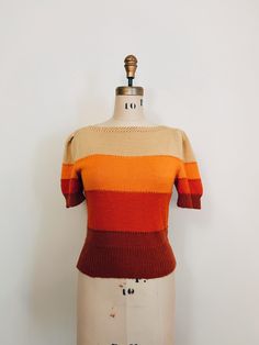 |d e s c r i p t i o n| *Y2K does 1930s *30s style handknit adorable short sleeve Fall sweater *colored layers of light yellow, orange, red, and rust  *cute puffed sleeves  *beautiful knit design at neckline  *pullover style  *very soft, likely a wool blend  |i n f o| tag: none, handmade  condition: excellent vintage condition. Some general minor piling  |m e a s u r e m e n t s| *measured flat, this sweater does have stretch* bust: 32" waist: 27" length: 19.5" sleeve length: 10" est. size: s/m Fitted Puff Sleeve Textured Knit Sweater, Retro Crew Neck Knit Top, Retro Fitted Textured Knit Tops, Retro Fall Sweater, Retro Textured Knit Crew Neck Top, Retro Fitted Tops For Fall, Fitted Retro Tops For Fall, Retro Knitted Brown Tops, Retro Brown Knitted Tops