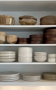 the shelves are filled with bowls and plates