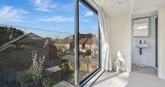 a bathroom with a large window looking out onto the street and houses in the distance