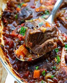 a spoon full of stew with meat and vegetables