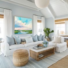 a living room filled with white furniture and lots of windows