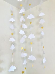 a baby crib mobile with clouds and stars hanging from it's sides in a nursery room