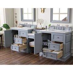 a bathroom vanity with two sinks and drawers in grey painted wood, along with mirrors on the wall