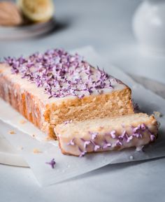 a piece of cake with purple sprinkles sitting on top of white paper