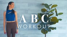 a woman standing next to a plant with the words abc workout