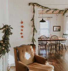 a living room filled with furniture and a fire place next to a christmas wreath on the wall