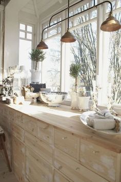 a kitchen with lots of counter space and hanging lights