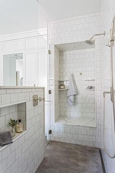 a white tiled bathroom with a walk in shower