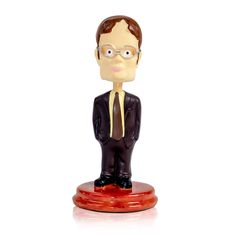 a figurine of a man in a suit and tie on a white background