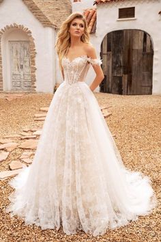 a woman in a wedding dress standing on the ground with her hands on her hips