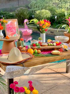 the table is set up with flowers, fruit and other items for an outdoor party