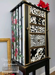 a black and white cabinet with red flowers on it