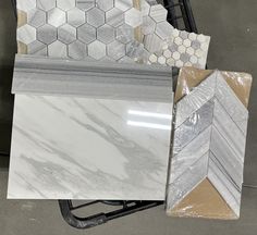 marble tiles are stacked on top of each other in different shapes and sizes, along with another type of tile