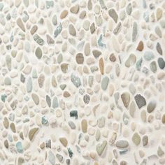 a white wall with many different colored rocks on it