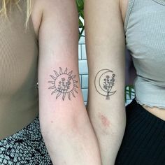 two women with matching tattoos on their arms, one has a sun and the other has a flower