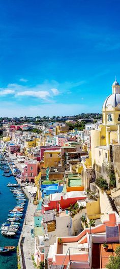 colorful buildings line the shore of a body of water with boats docked in it's harbor