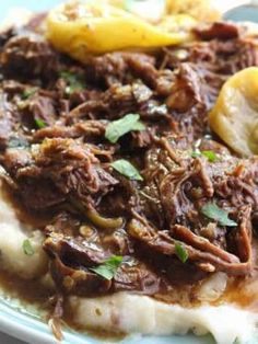 a close up of food on a plate with potatoes and meat