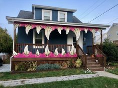 a blue house with white flowers painted on the front porch and steps leading up to it