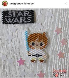 a star wars character made out of perler beads on a white background with pink and blue stars