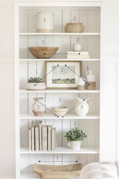 a white bookcase filled with lots of books