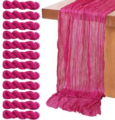 the pink scarf is on top of a wooden table