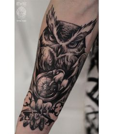 an owl tattoo on the arm with flowers