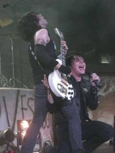 an image of two people playing guitars on stage