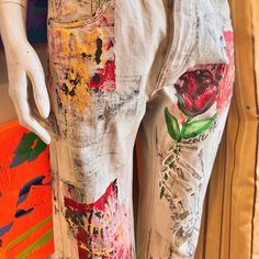 a white mannequin with flowers painted on it's pants and back legs