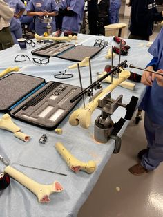 several medical instruments are on a table with people in scrubs and blue coats around them