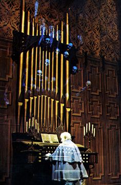 a woman standing in front of a pipe organ