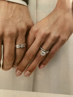 two people holding hands with wedding rings on their fingers