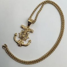 Embark on a journey of nautical elegance and spiritual significance with the Men's Stainless Steel Pendant Necklace featuring a gold anchor, nautical steering wheel, and Jesus cross from Innovato Design. This intricately crafted necklace brings together maritime symbolism and spiritual elements, creating a unique and meaningful accessory. The gold anchor and nautical steering wheel evoke the adventurous spirit of the sea, while the Jesus cross adds a touch of divine significance. Meticulously crafted from high-quality stainless steel, the pendant ensures durability and lasting shine. The accompanying chain completes the look, making it a versatile and stylish accessory for various occasions. Whether worn as a symbol of faith, a love for the sea, or a statement of personal style, this penda Gold Metal Jewelry With Compass Design, Gold Anchor Necklace In Nautical Style, Gold Nautical Anchor Necklace, Nautical Style Anchor Gold Jewelry, Nautical Anchor Gold Jewelry, Gold Nautical Anchor Jewelry, Nautical Anchor-shaped Gold Jewelry, Nautical Anchor Shaped Gold Jewelry, Yellow Gold Nautical Anchor Jewelry