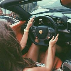 a woman driving a car with her hands on the steering wheel