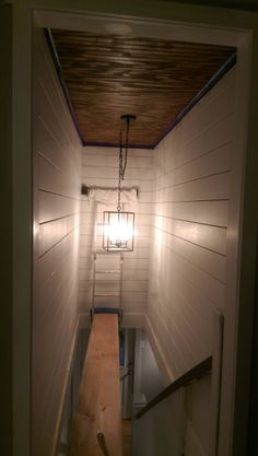 the light is on in an empty room with wood flooring and white painted walls