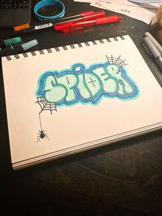 a notebook with graffiti written on it next to some markers and crayon pens