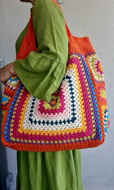 a woman is carrying a crocheted bag