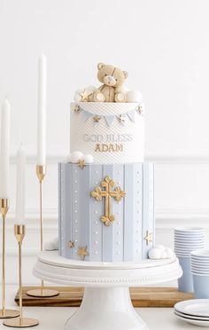 there is a blue and white cake with gold decorations on the top that has a teddy bear in it