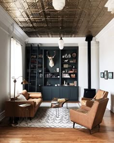 a living room filled with furniture and a fire place next to a book shelf full of books